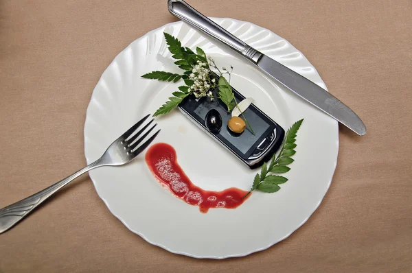 cep telefonu yeşillik ve ketçap ile süslenmiş beyaz tabak