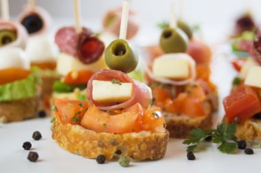 Bruschetta bread with prosciutto, olives and cheese clipart