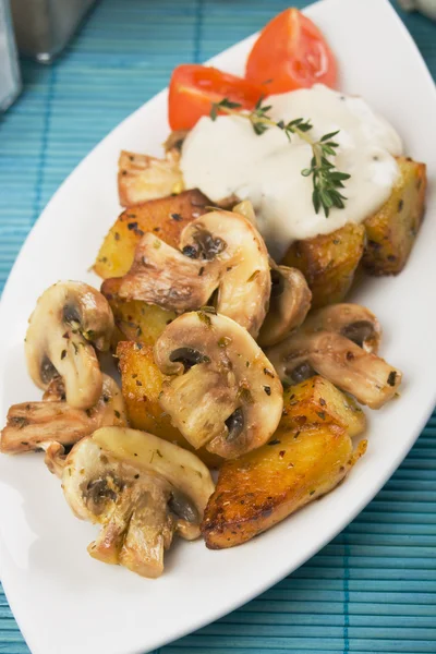 Грибы чапиньон с жареным картофелем и белым соусом — стоковое фото