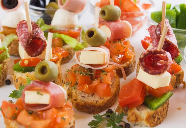Bruschetta with prosciutto, olive, cheese and tomato — Stock Photo, Image