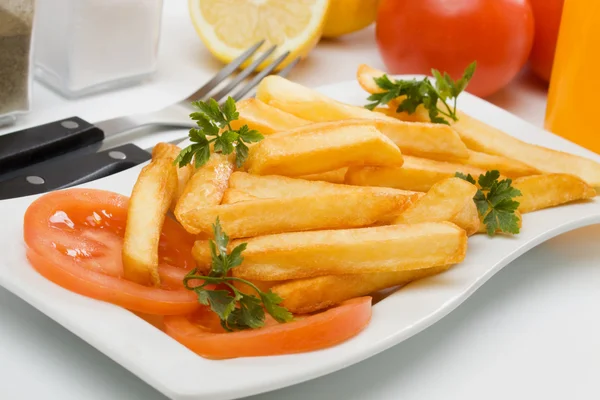 Franse frietjes geserveerd met verse tomaat — Stockfoto