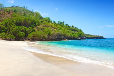 View from a sandy beach on rocks at ocean. Indonesia, Bali clipart