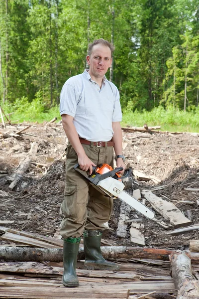 A férfi a fán láncfűrészt fűrészel. — Stock Fotó