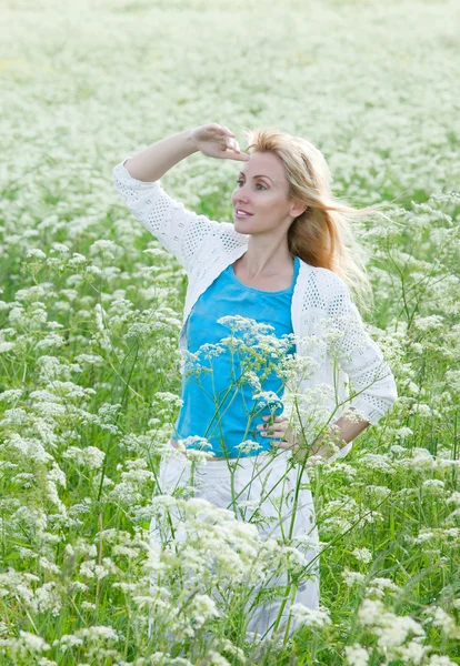 Счастливая молодая женщина в поле белых диких цветов — стоковое фото