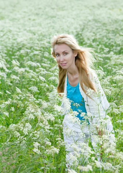 The happy young woman in the field of white wild flowers — Stock Photo, Image