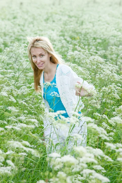 The happy young woman in the field of white wild flowers — Stock Photo, Image