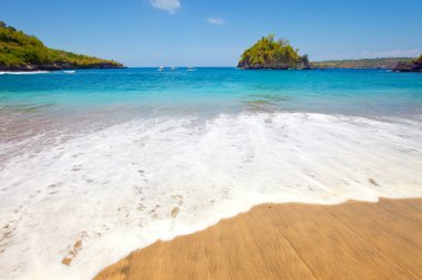 View from a sandy beach on rocks at ocean. Indonesia, Bali clipart