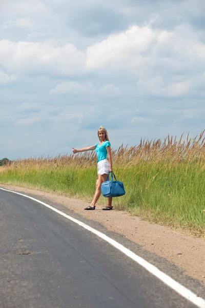 stock image Hitchhiking girl votes on road