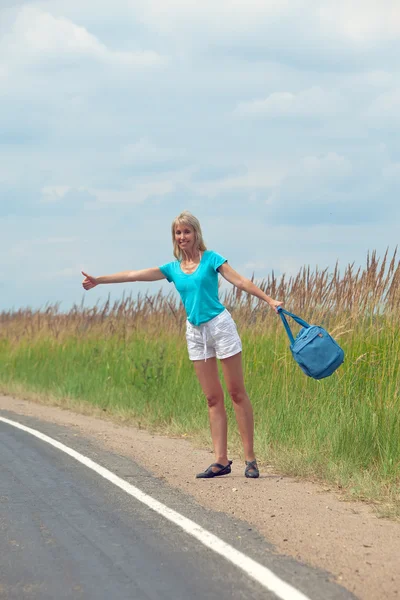 stock image Hitchhiking girl votes on road