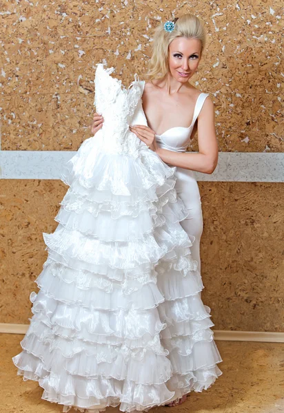 A noiva feliz experimenta um vestido de noiva — Fotografia de Stock