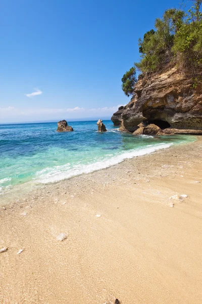 Vista de uma praia arenosa sobre rochas no oceano. Indonésia, Bali — Fotografia de Stock