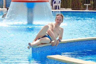 The happy man lies in pool in an aquapark