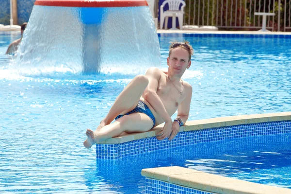 Den glada mannen ligger i pool i en vattenpark — Stockfoto