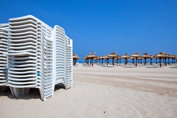 Verlaten strand en strand parasols — Stockfoto