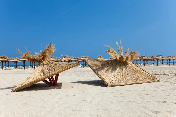 Beach, beach umbrellas and two tops from beach umbrellas — Stock Photo, Image