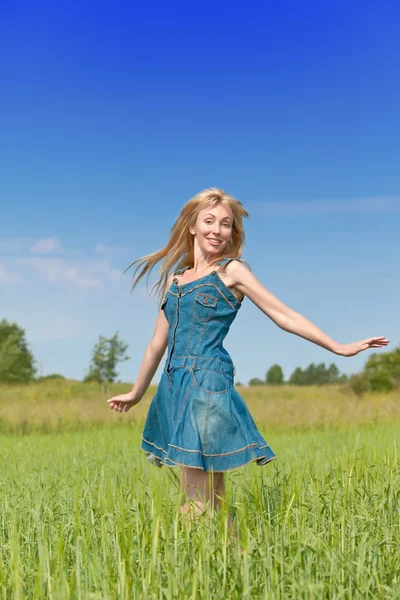 The happy young woman in the field of green ears — Stock Photo, Image