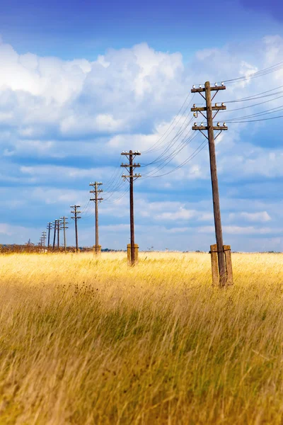 stock image Old wooden electric pillar in the field