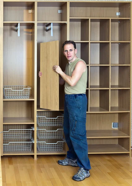 The man is engaged in assemblage of a new wardrobe — Stock Photo, Image
