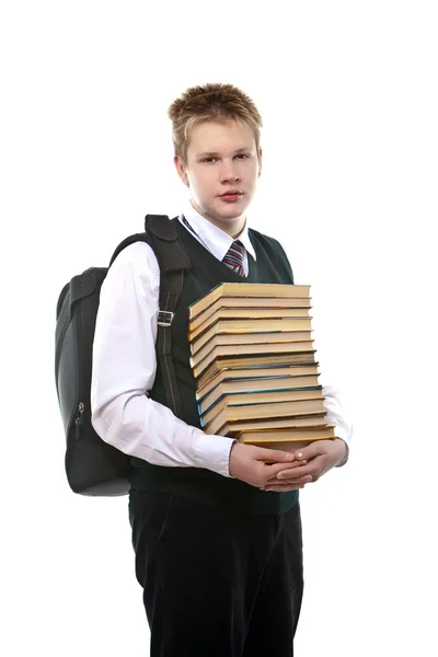 Skolpojke i en skoluniform med en stor förpackning med böcker — Stockfoto