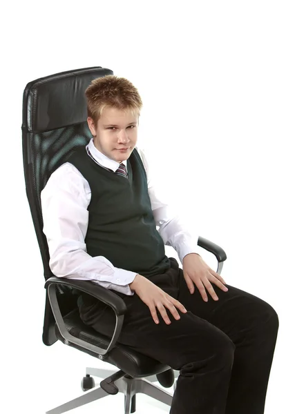 The schoolboy in a school uniform sits — Stock Photo, Image