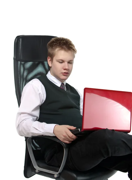Skolpojke i office fåtölj, med den bärbara datorn — Stockfoto