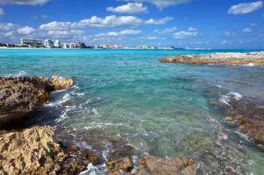 Cancun.Rocky coast, the sea and city in the distance clipart