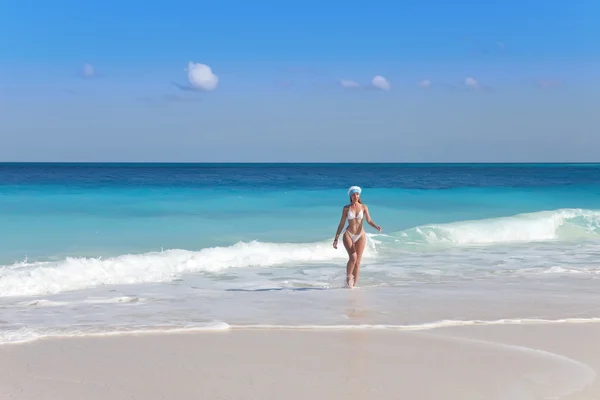 Flickan i tomtens hatt lämnar havet — Stockfoto