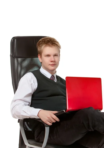Lo scolaro felice in poltrona di ufficio, con il computer portatile — Foto Stock