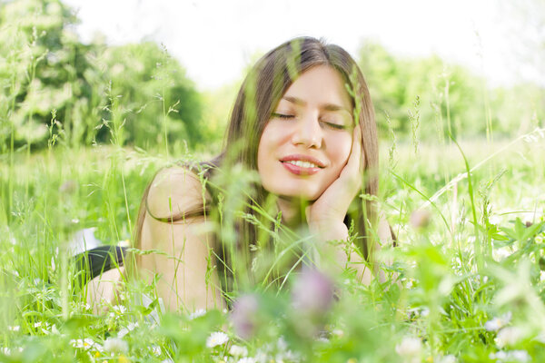 Portrait of beauty girl relaxing on green fields.