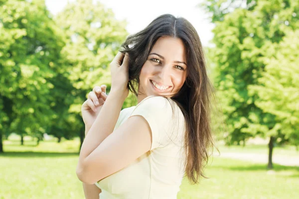Счастливая молодая женщина наслаждается прекрасным весенним днем в парке — стоковое фото