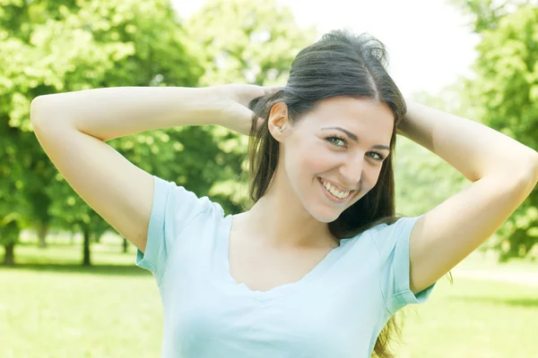 Glad ung kvinna njuter på vacker vårdag i parken — Stockfoto