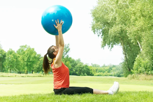 Chica de fitness haciendo ejercicio con la pelota de pilates al aire libre — Foto de Stock