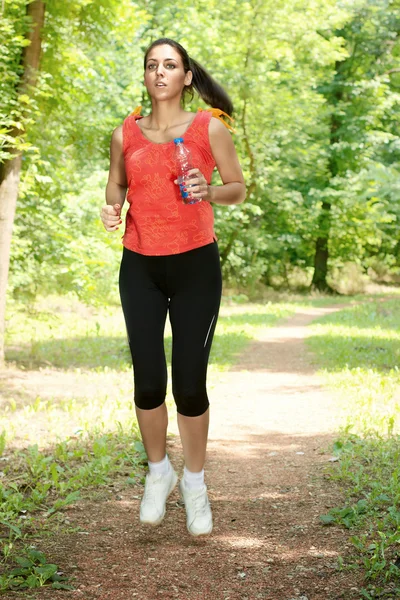 Fitness dívka jogging lesem v létě — Stock fotografie