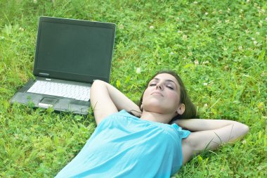 güzel bir genç kadın ile laptop çimenlerin üzerinde rahatlatıcı