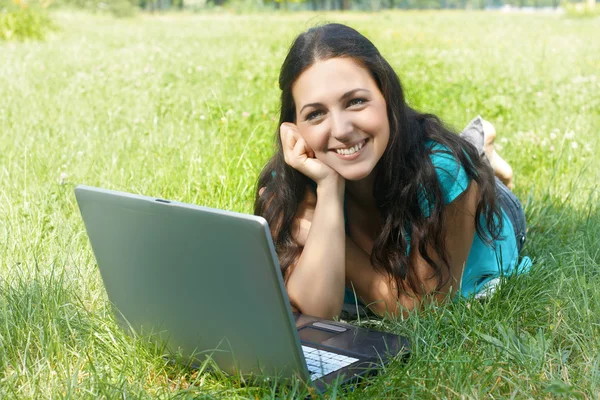 Portrét krásné mladé ženy používat přenosný počítač v parku — Stock fotografie