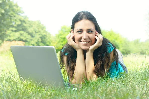 Портрет красивої молодої жінки, що використовує ноутбук у парку — стокове фото
