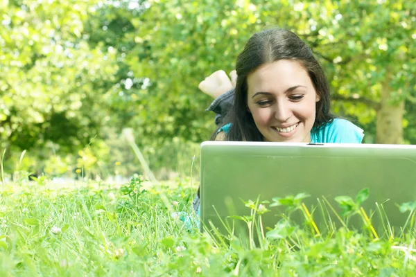 Krásná mladá žena pomocí přenosného počítače na venkovní — Stock fotografie