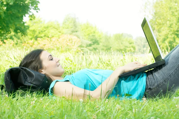 Szczęśliwy uczeń korzysta z laptopa w parku — Zdjęcie stockowe
