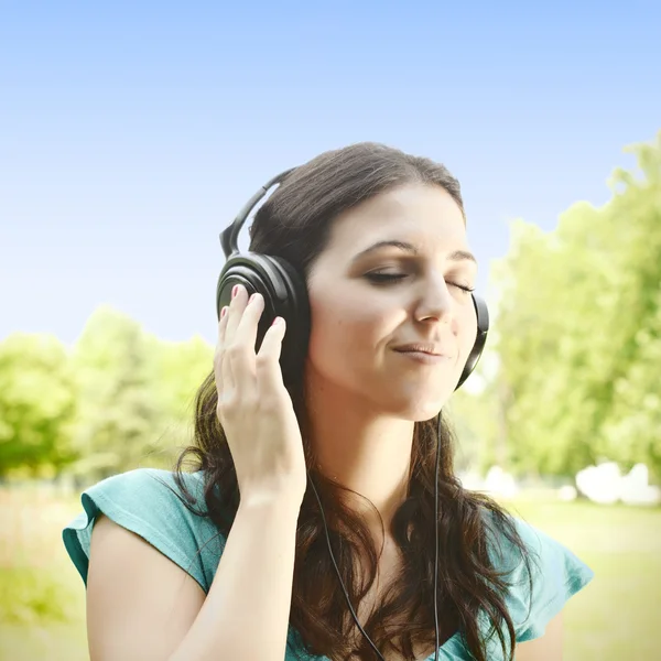 Beleza jovem com fones de ouvido ao ar livre — Fotografia de Stock