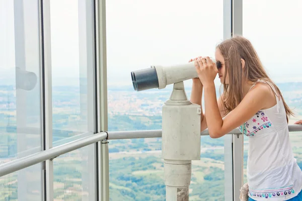 Девушка смотрит через туристический телескоп — стоковое фото