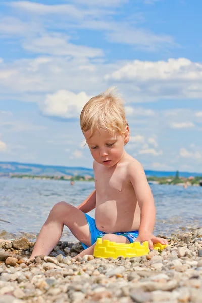 Дворічний хлопчик грає на пляжі — стокове фото