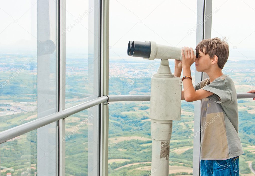 Boy looking through tourist telescope