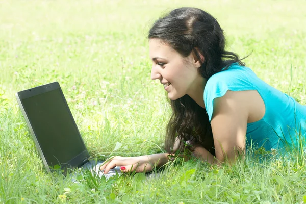 Mujer joven feliz usando el ordenador portátil al aire libre — Foto de Stock