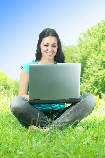 Gelukkig jonge vrouw met laptop buiten — Stockfoto
