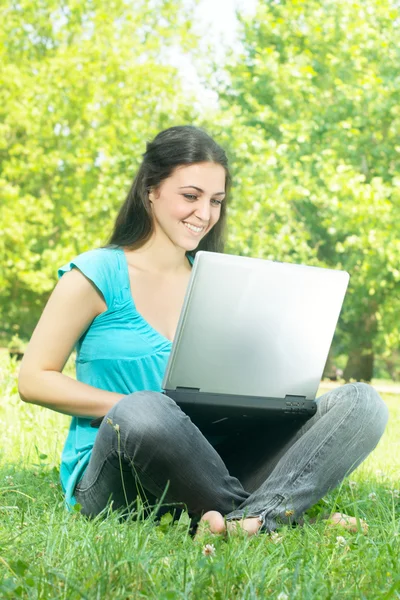 Happy young woman using laptop outdoors — Stock Photo, Image