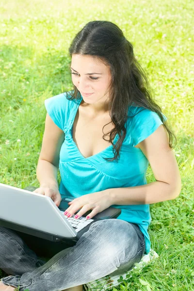 Happy young woman using laptop outdoors — Zdjęcie stockowe