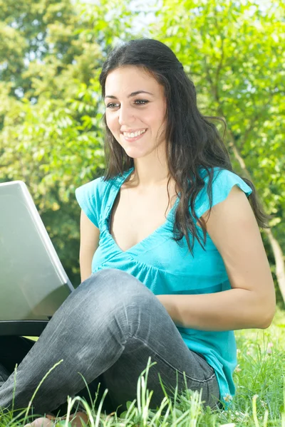 Happy young woman using laptop outdoors — Stock Photo, Image
