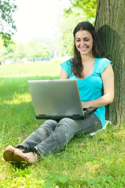 Mujer joven feliz usando el ordenador portátil al aire libre —  Fotos de Stock