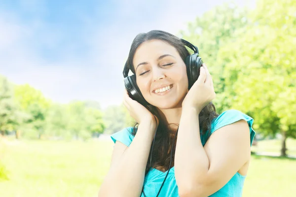 Belleza mujer joven con auriculares al aire libre — Foto de Stock