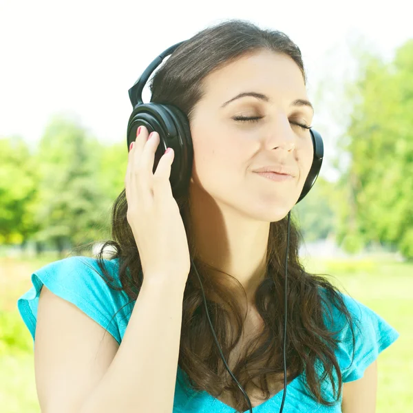 Belleza mujer joven con auriculares al aire libre —  Fotos de Stock